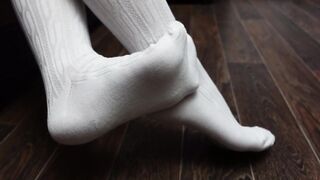 Sexy schoolgirl puts on white knee socks and shows her feet